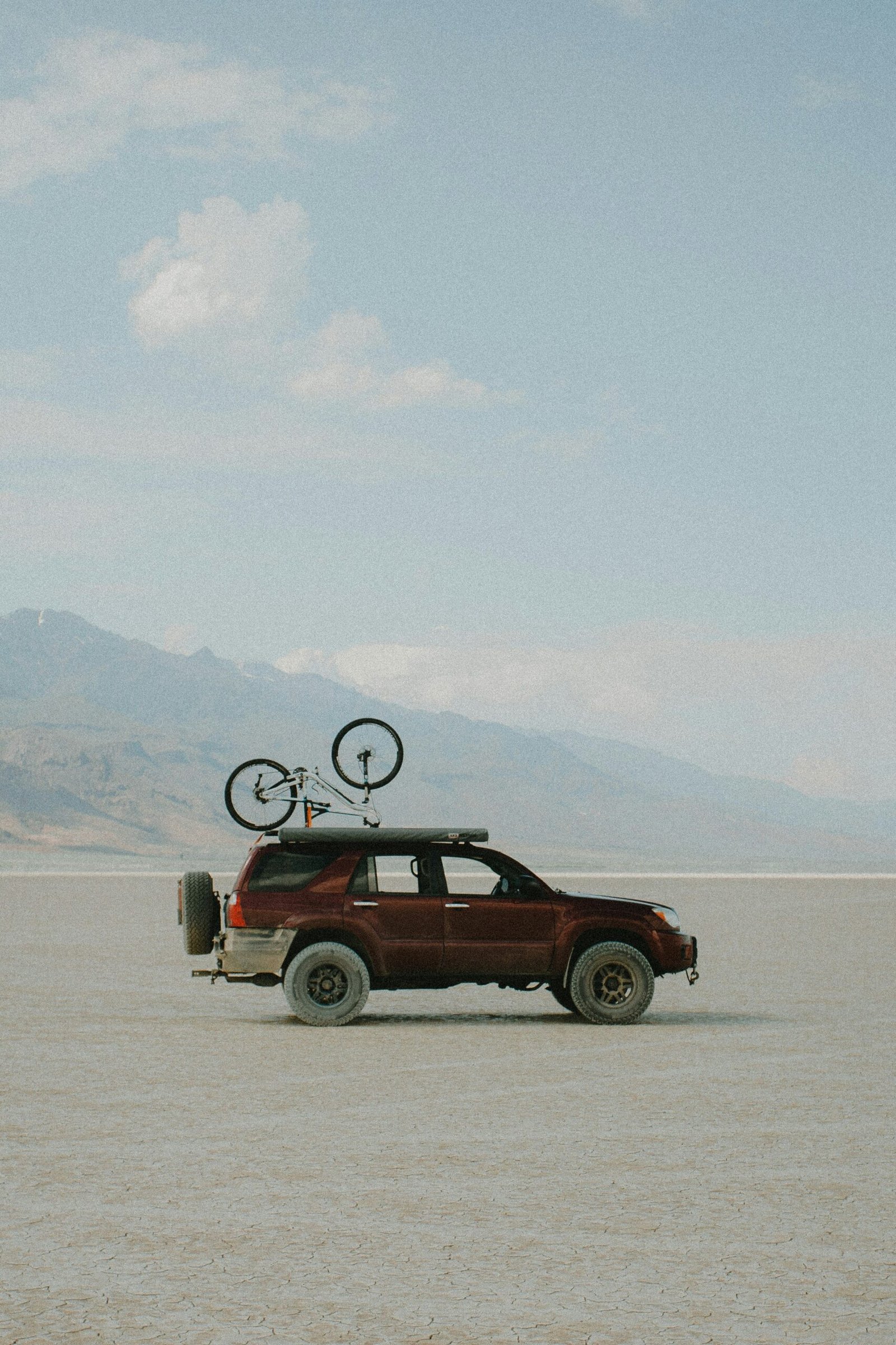 a red truck with a bicycle on top of it's roof